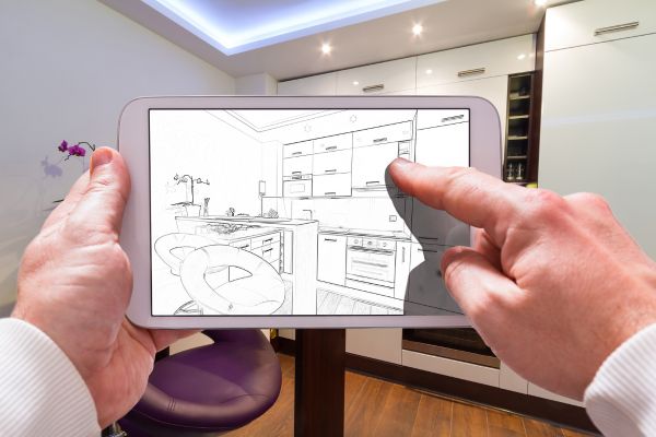 schitele unui proiect pe telefon, in spate mobilierul executat conform schitelor